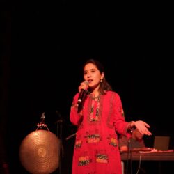 Colour photograph of Avita Maheen from Kapolnik Rekha talking into a microphone at WORM