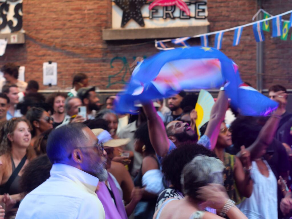Colour photo by WORM club programmer Frederik Teixeira showing a street scene of partying and creative people during the block party for the Farroffa x WORM event July 2026