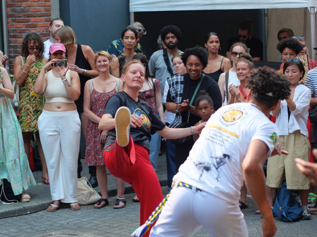Colour photo by WORM club programmer Frederik Teixeira showing a street scene of partying and creative people during the block party for the Farroffa x WORM event July 2026