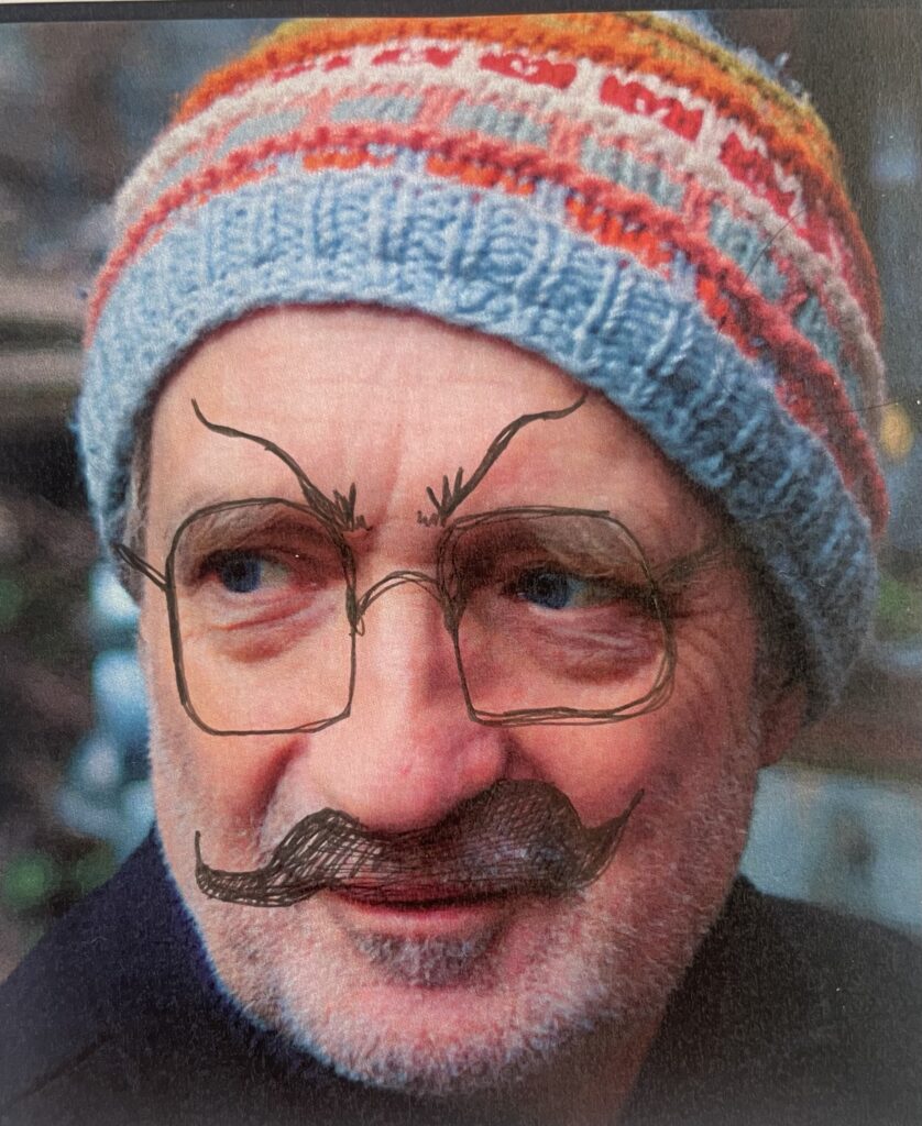 Colour photo of a colour scan of Lukas Simonis wearing a bobble hat. The photo has been scribbled on